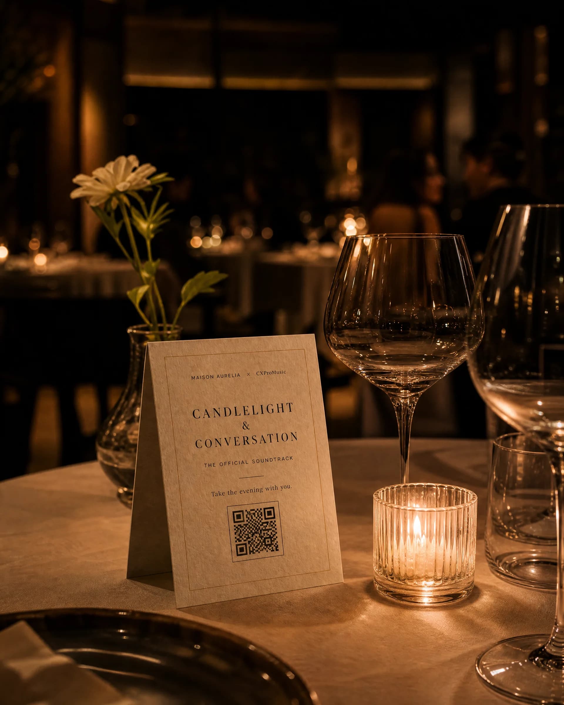 A signature table card beside a candle and glassware on a laid table.